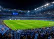 Stadion Liga Inggris di malam hari dengan lampu sorot menyala