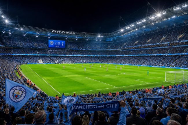 Stadion Liga Inggris di malam hari dengan lampu sorot menyala